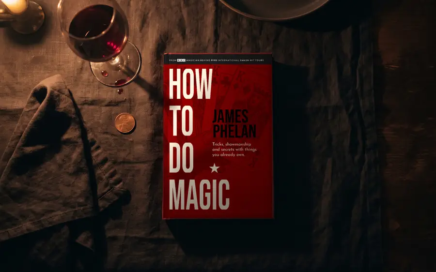How to do Magic hardback on a dark candlelit dinner table beside a glass of wine and a napkin